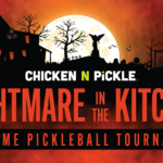 Halloween-themed poster with haunted houses, pumpkins, bats, and a full moon. Text: “CHICKEN N PICKLE. NIGHTMARE IN THE KITCHEN. COSTUME PICKLEBALL TOURNAMENT.” Spooky, orange and black color scheme.