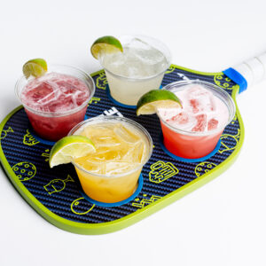 Pickleball Paddle holding four small margraitas with limes, Mango, Classic, Spicy Blackberry, & Strawberry flavors