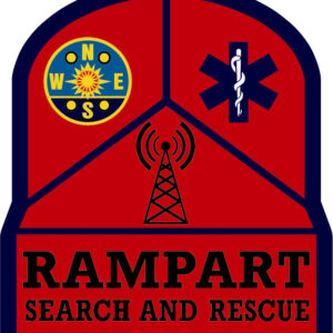 A red and navy badge reads RAMPART SEARCH AND RESCUE. It features a compass, medical symbol, and radio tower above the text, representing navigation, medicine, and communication. A giveback benefiting vets for youth supports this mission.