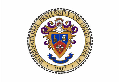 A circular crest with a gold border reads International Fraternity of Delta Sigma Pi 1907 surrounding a detailed coat of arms featuring a shield, knight’s helmet, and various symbols in red, blue, and gold.