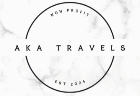 A minimalist white logo with a black circle. Inside, the text reads AKA TRAVELS in bold letters. Above, it says NON PROFIT, and below, EST 2024. The background has a subtle marble texture.
