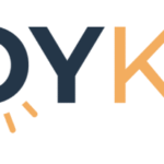 Logo reading JOY KC with JOY in dark blue and KC in orange. The O in JOY features yellow rays below it, resembling a rising sun. White background. Design celebrates Giveback Benefiting Vets for Youth.