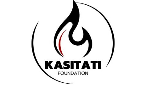 Logo for Kasitati Foundation featuring a stylized black flame with a red accent, encircled by two black curved lines. The design symbolizes giveback, benefiting vets and youth. KASITATI appears bold, with FOUNDATION below in smaller letters.