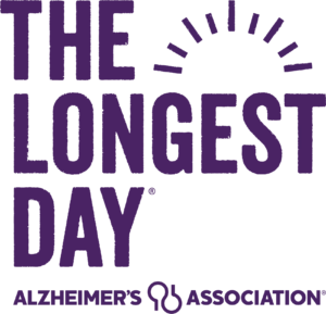 The image features the text The Longest Day with a sun graphic, and Alzheimer's Association below, representing a giveback awareness event benefiting vets and youth. The text and graphics are in purple.