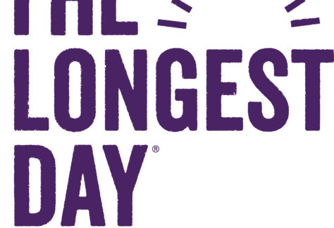 The image features the text The Longest Day with a sun graphic, and Alzheimer's Association below, representing a giveback awareness event benefiting vets and youth. The text and graphics are in purple.