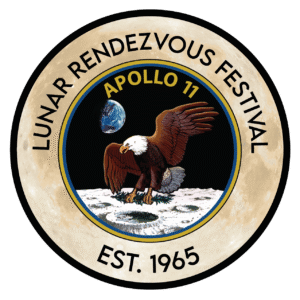 A circular logo for the Lunar Rendezvous Festival features “Est. 1965,” an eagle landing on the Moon, Earth in the sky, and “Apollo 11,” celebrating a 10% Giveback to Clear Creek Education at Chicken N Pickle Webster.