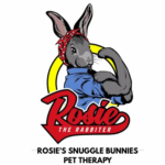 A gray bunny in a red polka-dot headband and blue shirt flexes its arm like Rosie the Riveter. Bold red text reads "Rosie the Rabbiter," with "Rosie’s Snuggle Bunnies Pet Therapy" below. 10% Giveback to Asbury Church at Chicken N Pickle.