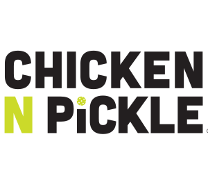 Chicken N Pickle logo with bold black text. The N is bright green, and the I in PICKLE is dotted with a small pickleball, referencing the companys food and pickleball theme. Background is light gray.